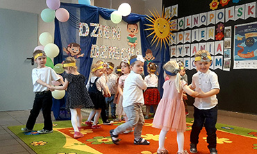Dzieci tańczą w kółeczkach