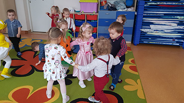 Na zdjęciu widać pięcioro dzieci bawiących się w kółku.