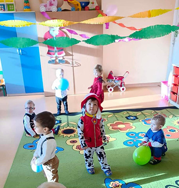 Dzieci bawią się balonami, część tańczy indywidualnie.