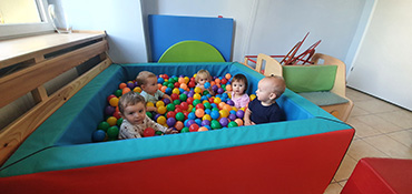 Dzieci bawią się w basenie z kulkami na sali sensorycznej.