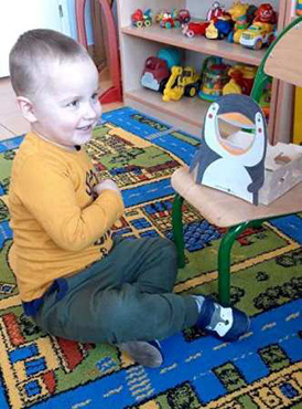 Chłopiec karmi „Żarłocznego pingwina”.