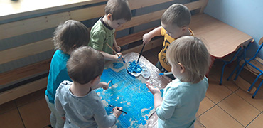 Dzieci wspólnie malują farbami dużą chmurę, potrzebną do stworzenia plakatu.