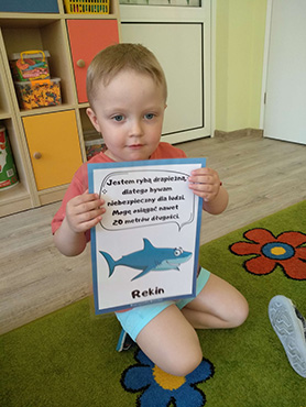 chłopczyk trzyma ilustracje rekina