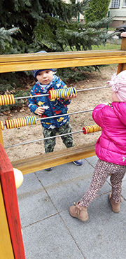 Zdjęcie siódme przedstawia dwójkę dzieci liczące kolorowe krążki.